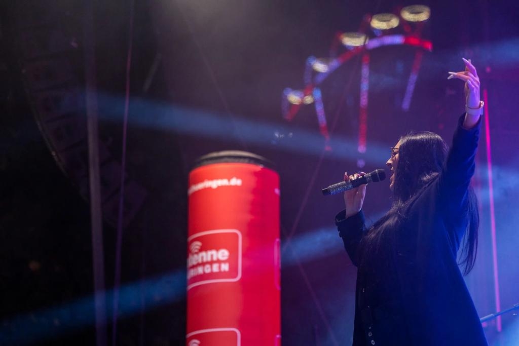 Sängerin im weissem Scheinwerferlicht bei einem Stadtfest